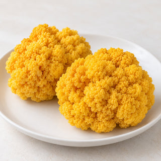 Illustrative fresh Gold Ear mushroom clusters on a plain white plate